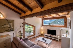 a living room with a couch and a tv at Mansarda con vista lago in Sulzano