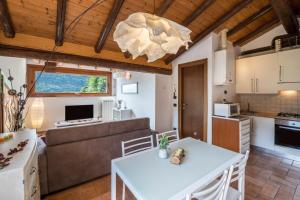 a kitchen and living room with a table and a couch at Mansarda con vista lago in Sulzano