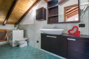 a bathroom with a sink and a toilet at Mansarda con vista lago in Sulzano +23 photos