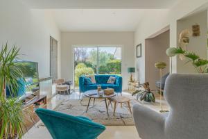 a living room with a blue couch and a table at Villa Saint-Martin - Pompignac in Pompignac