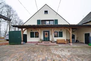 a house with a green door and a bench at Alte Revierförsterei in Börfink