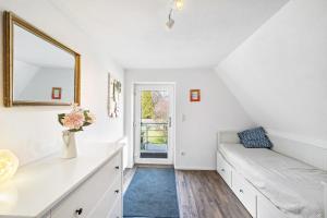 a white living room with a couch and a mirror at Ferienwohnung Bayerl in Kirchseeon