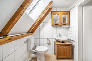 a bathroom with a toilet and a sink at Ferienwohnung Bayerl in Kirchseeon +18 photos