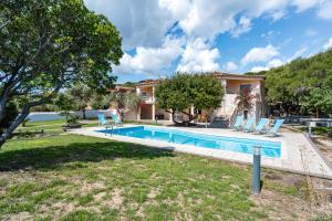 a villa with a swimming pool and a house at La vela gialla in Cala Liberotto