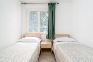 two twin beds in a room with a window at La vela gialla in Cala Liberotto +20 photos