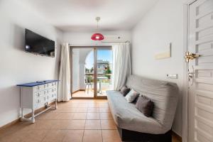 a living room with a couch and a sliding door at Apartamento Isla Blanca in Es Pujols