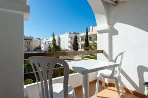 a table and chairs on a balcony with a view at Apartamento Isla Blanca in Es Pujols