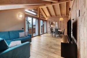 ein Wohnzimmer mit einem blauen Sofa und einem Tisch in der Unterkunft Quattropassi Bormio in Bormio