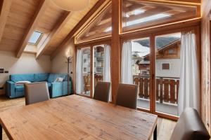 ein Esszimmer mit einem Tisch und einem großen Fenster in der Unterkunft Quattropassi Bormio in Bormio