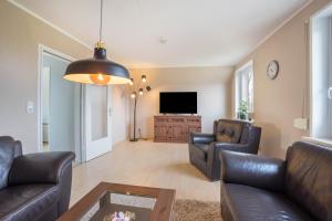 a living room with two couches and a flat screen tv at Ferienwohnung Krempermoor 2 in Krempermoor