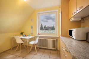 a kitchen with a table and chairs and a window at Ferienwohnung Krempermoor 2 in Krempermoor