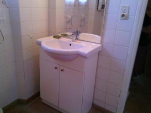 a white sink in a bathroom with white tiles at Gite La Combe de Melvieu in Viala-du-Tarn +9 photos