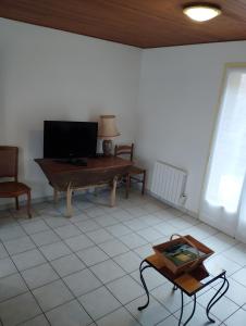 a living room with a piano and a table at Gite La Combe de Melvieu in Viala-du-Tarn