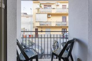 two chairs on a balcony with a view of a building at Casavacanzefranca - 14 in Terrasini