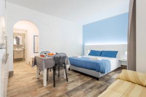 a bedroom with a bed and a table and a bathroom at Casavacanzefranca - 14 in Terrasini