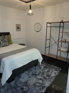 a bedroom with a large bed and a shelf at Villa Tlhago Lodge in Ga-Mothapo