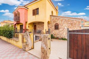 a house with a wooden gate and a fence at Il Giglio in Cardedu