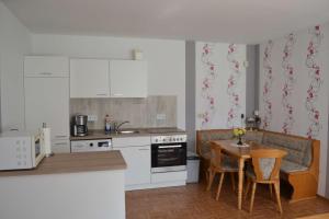 a kitchen with white appliances and a table with chairs at Ferienwohnung Meins in Friesoythe