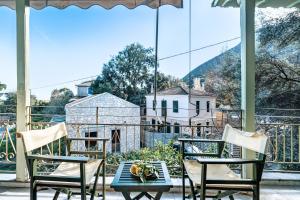 a table and chairs on a porch with a view of a house at Old Boat 12 in Nikiana +7 photos