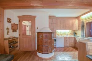 a kitchen with wooden cabinets and an open door at Apartments Christa App A in Ortisei