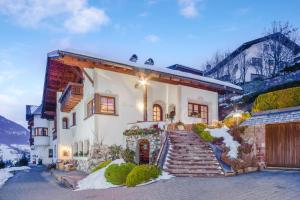 a white house with snow on the ground at Apartments Christa App A in Ortisei