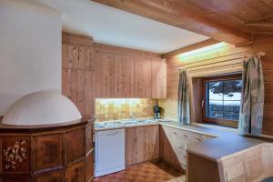 a kitchen with wooden cabinets and a sink and a window at Apartments Christa App A in Ortisei +15 photos