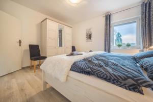 a bedroom with a bed and a window and a chair at Ferienhaus an der Göhrde in Zernien