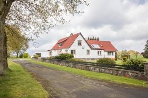 a white house with a red roof on a road at Ferienhaus an der Göhrde in Zernien