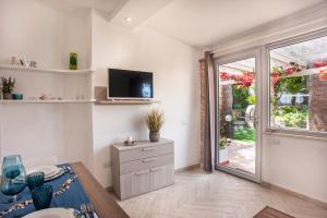 a living room with a table and a sliding glass door at Casa Petunia in Sarroch
