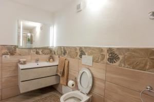 a bathroom with a toilet and a sink and a mirror at Casa Petunia in Sarroch +13 photos
