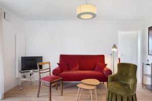 a living room with a red couch and chairs at Gallushof in Lauterbach