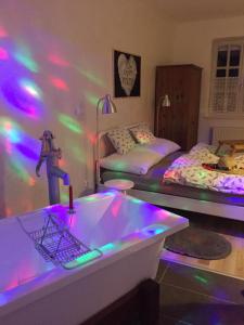 a room with two beds and a bathtub with lights at Viktória Inn Tihany in Tihany