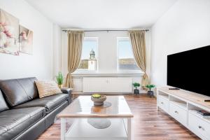 a living room with a couch and a flat screen tv at Wohnung am Hagener Hbf - 4 Og in Hagen