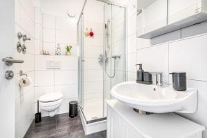 a white bathroom with a sink and a toilet at Wohnung am Hagener Hbf - 4 Og in Hagen