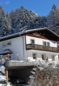 a snow covered building with a car in front of it at Apartment Sciadules in Ortisei
