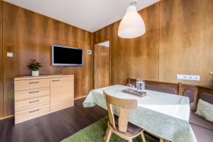 a dining room with a table and a tv at Apartment Sciadules in Ortisei