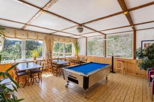 a pool table in a room with tables and chairs at Haus Sonnenberg in Willingen