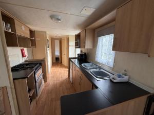 a kitchen with a sink and a counter top at Sunnymede G20 with Hot Tub - pet friendly, Wifi, bed linen - Meadow Lakes Caravan & Lodge Hire in Ingoldmells