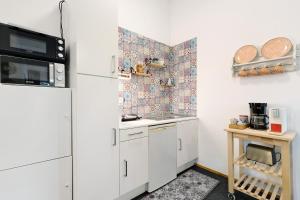 a small kitchen with a refrigerator and a table at Albrechtshof Apartment 3 in Potsdam