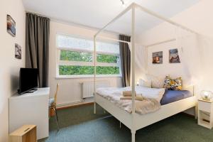a bedroom with a canopy bed and a television at Albrechtshof Apartment 3 in Potsdam