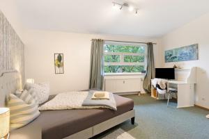 a bedroom with a bed and a desk and a window at Albrechtshof Apartment 3 in Potsdam