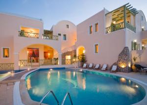 a villa with a swimming pool in front of a building at Anassa Deluxe Suites in Kamari