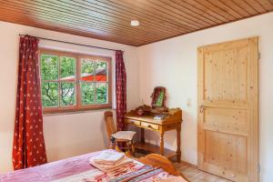 a bedroom with a desk and a window and a bed at Landhaus Lucia in Oberau