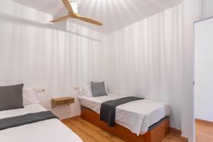 a bedroom with two beds and a ceiling fan at Apartamento Palomera Blanes in Blanes