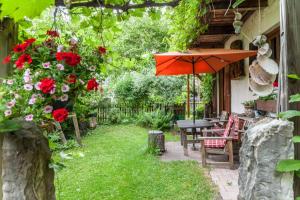 a patio with a table and an umbrella and flowers at Landhaus Lucia in Oberau