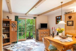 a dining room with a wooden table and a tv at Landhaus Lucia in Oberau