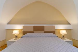 ein Schlafzimmer mit einem großen Bett und zwei Lampen in der Unterkunft La rimesa di Tittì - Anna in Alezio