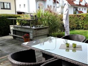 a patio with a table and chairs on a deck at Ferienwohnung Laura in Langenargen