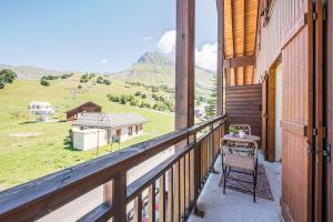 a balcony with a table and a view of a mountain at Charmant Duplex Au Pied Des Pistes in Albiez-Montrond