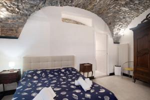 a bedroom with a bed and a stone wall at Inglese, borgo dei pescatori in Cervo